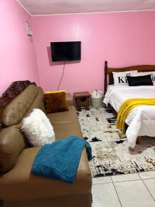 ein Wohnzimmer mit einem Sofa und einem Bett in der Unterkunft Ruth's Studio - Kericho in Kericho