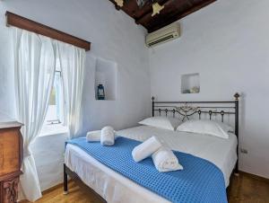 1 dormitorio con 1 cama con toallas en Thavma in Sifnos, en Apollonia