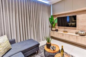 a living room with a couch and a tv at Zimbali Lakes Boulevard Suite 134 in Sheffield Beach