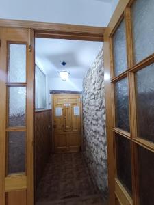 um corredor com uma porta de madeira e uma parede de pedra em La Casassa em Les Coves de Vinroma