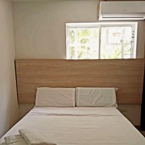 - un lit dans une chambre avec fenêtre dans l'établissement Aw Hotel Pasarela Real, à Cali