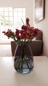 a vase filled with flowers sitting on a table at Aw Hotel Pasarela Real in Cali