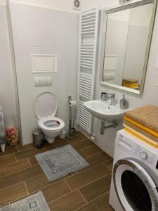een badkamer met een toilet, een wastafel en een wasmachine bij Apartmán Sabína in Liptovský Mikuláš