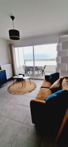 Appartement Mont-Blanc - 3 étoiles في Gillon: غرفة معيشة مع أريكة وطاولة