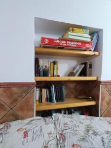 uma estante cheia de livros ao lado de uma cama em La Casassa em Les Coves de Vinroma