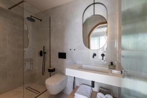 a bathroom with a sink and a shower and a toilet at Nōema Premium Stay in Neos Marmaras