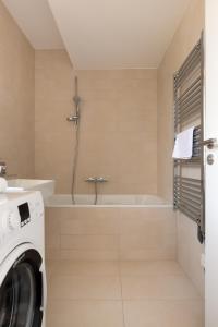 a bathroom with a tub and a washing machine at Neu zentral und ruhig an der U2 / Stadion in Vienna