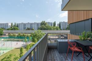 a balcony with a table and chairs and a tennis court at Neu zentral und ruhig an der U2 / Stadion in Vienna