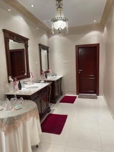 a large bathroom with two sinks and a chandelier at The luxury Home in Abha