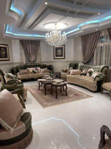 a living room with couches and a chandelier at The luxury Home in Abha