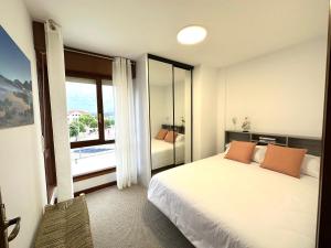 een slaapkamer met een bed en een groot raam bij Apartamento El Olivo in Noja