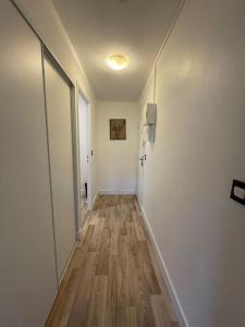 een hal met witte muren en een houten vloer bij Studio au pied du tram avec Jardin et Parking in Montpellier