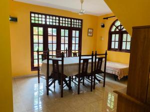 - une salle à manger avec une table, des chaises et un lit dans l'établissement Florence Residence Makola, à Kadawata