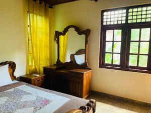 - une chambre avec un miroir, un lit et une commode dans l'établissement Florence Residence Makola, à Kadawata