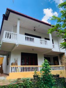 Cette maison blanche dispose d'un balcon sur le côté. dans l'établissement Florence Residence Makola, à Kadawata