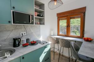 eine Küche mit einer Spüle und einer Theke mit Stühlen in der Unterkunft Apartments & Rooms ARCH in Mostar