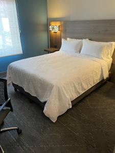 ein großes weißes Bett in einem Zimmer mit Stuhl in der Unterkunft Holiday Inn Express Mexico City Satelite, an IHG Hotel in Mexiko-Stadt