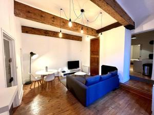 een woonkamer met een blauwe bank en een tafel bij Grenoble Hypercentre - Appartement vieille ville - Wifi in Grenoble