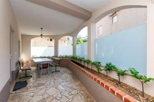 a balcony with a table and plants in a building at Apartments Kate in Duće