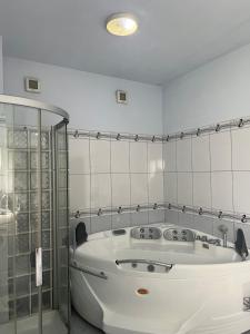 a white bath tub in a bathroom with a glass door at Guest House Pulake in Berat +47 photos