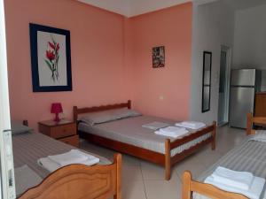 2 camas en una habitación con paredes rosas en Rexhos Studios, en Himare