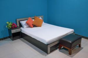 a bed with colorful pillows and a stool in a room at Sunny Side inn in Midu