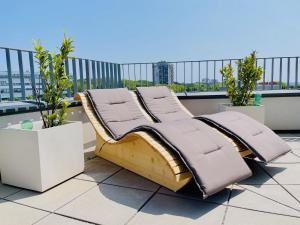 a bed sitting on top of a roof at Sonnenwohnen Penthouse direkt bei U-Bahn und Therme Wien mit Top Anbindung ins Zentrum in Vienna