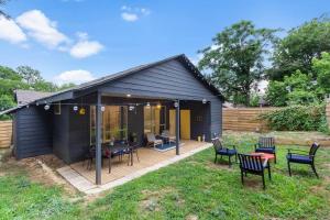 a black shed with chairs and tables in a yard at Bishop Arts Getaway! Fenced Yard, King Bed + More in Dallas