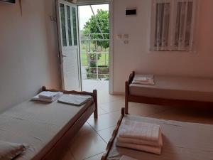 a room with two beds and a sliding glass door at Rexhos Studios in Himare