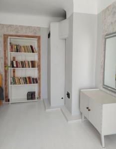um quarto branco com um espelho e uma estante de livros em Jõevaara Veskitalu 