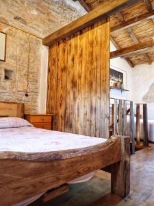 sypialnia z łóżkiem z drewnianą ścianą w obiekcie Cottage al Merlo Olivo w mieście Buje