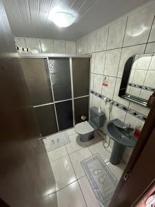 een kleine badkamer met een wastafel en een toilet bij Quarto Deluxe em Foz piscina wifi estacionamento cozinha E AR in Foz do Iguaçu