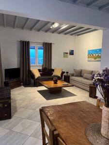 una gran sala de estar con sofás y una mesa. en Irene's Residence en Mykonos