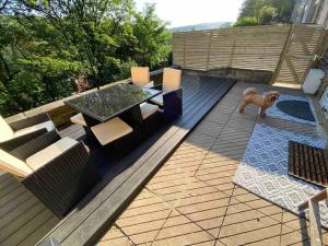 a dog standing on a deck with a table and chairs at Bowie's Abode in Sowerby Bridge