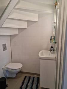 bagno bianco con servizi igienici e lavandino di Apartment near center / free P ad Ålesund