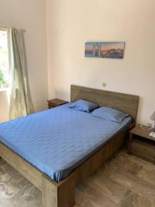um quarto com uma cama com lençóis azuis e uma janela em Apartment near the Beach Paradise Mikra Mantinia em Arkondikó