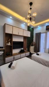 a bedroom with two beds and a chandelier at Resort Style Condo Walkable to Mall of Asia in Manila