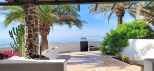 patio con palme e vista sull'oceano di Loro Verde a Playa Honda