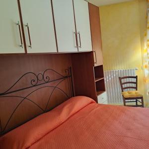 1 dormitorio con 1 cama con cabecero de madera en Casa Vacanze “ Fonte del Borgo”, en Lanciano