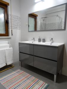a bathroom with a sink and a mirror at Casa das Andorinhas in Lourinhã