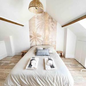 a bedroom with a bed with two magazines on it at ~L’Arche de l’Heurt~ in Le Portel