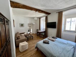 a bedroom with a bed and a living room with a couch at Apartment Georgstor im Posthalterhof mit Sauna in Blankenheim