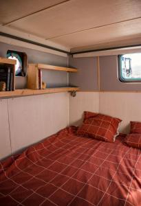 1 dormitorio con 1 cama en una habitación pequeña en Bateau SCOPA en Rouen