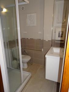 Un baño con inodoro y ducha de cristal. en Appartement à 5mn de la plage en RdC, en Narbonne-Plage