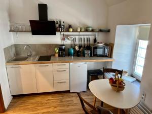 eine Küche mit einem Tisch, auf dem eine Obstschale steht in der Unterkunft Apartment Georgstor im Posthalterhof mit Sauna in Blankenheim