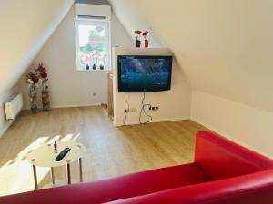 a living room with a red couch and a tv at apartment4me in Burgau