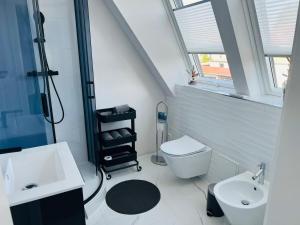 a bathroom with a sink and a toilet and a window at apartment4me in Burgau