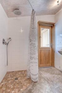 een badkamer met een douche, een wastafel en een deur bij Stunning Medieval Getaway in Vic-la-Gardiole