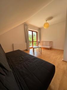 a bedroom with a bed and a large window at Dom pod głogami in Szczytno