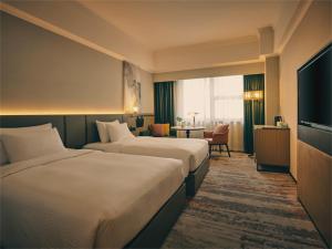 Uma cama ou camas num quarto em Wanda Yi Hotel Wuxi